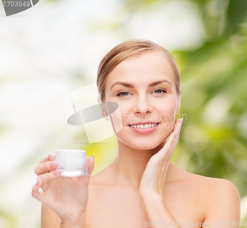 Image of woman applying cream on her skin