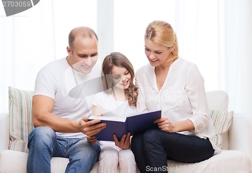 Image of smiling parents and little girl with at home