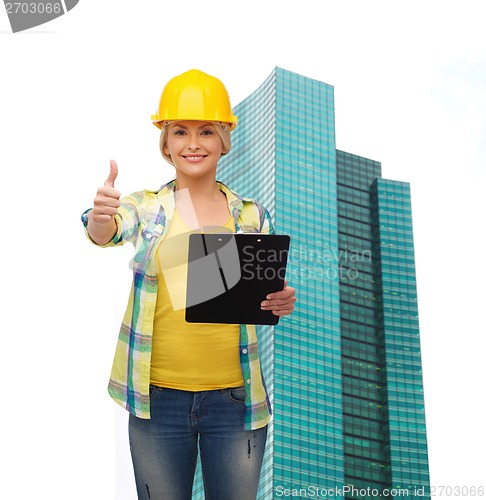 Image of smiling woman in helmet with clipboard