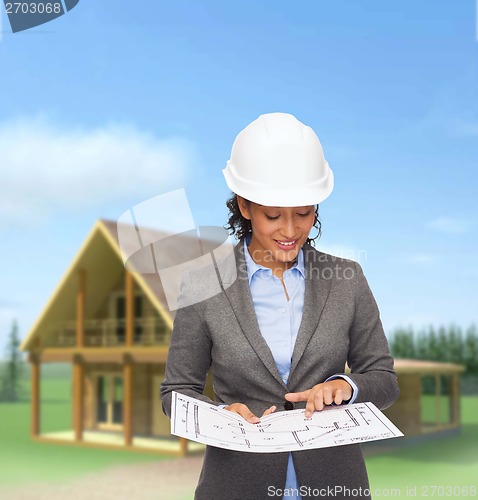 Image of businesswoman in white helmet with blueprint