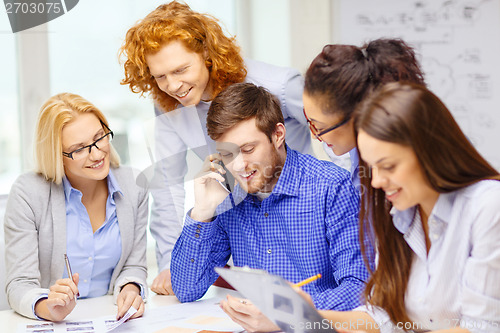 Image of creative team with papers and clipboard at office