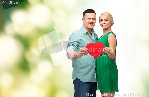 Image of smiling couple holding big red heart