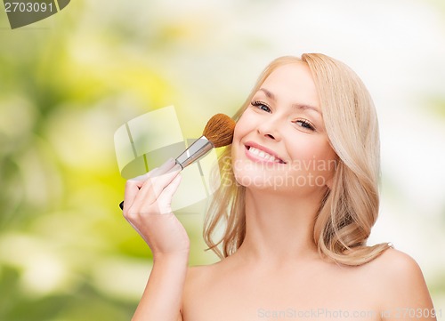 Image of beautiful woman with closed eyes and makeup brush