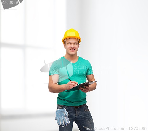 Image of smiling man in helmet with clipboard