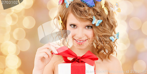 Image of teenager with butterflies in hair opening present