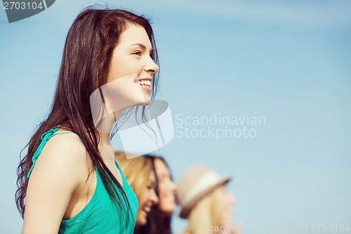 Image of girl with friends walking on the beach