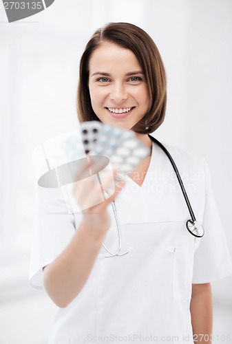 Image of doctor with blister packs of pills