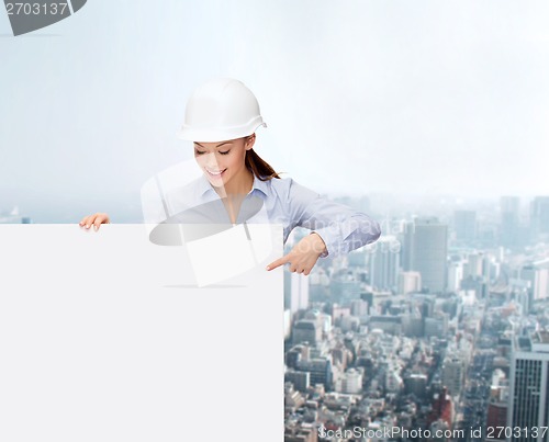 Image of businesswoman in helmet pointing finger to board