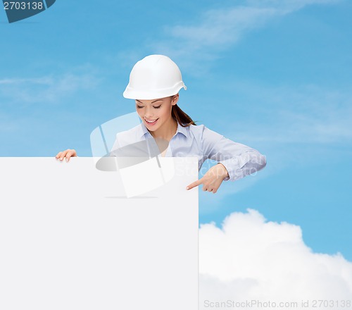 Image of businesswoman in helmet pointing finger to board