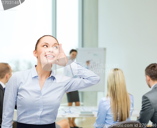 Image of smiling businesswoman listening gossig