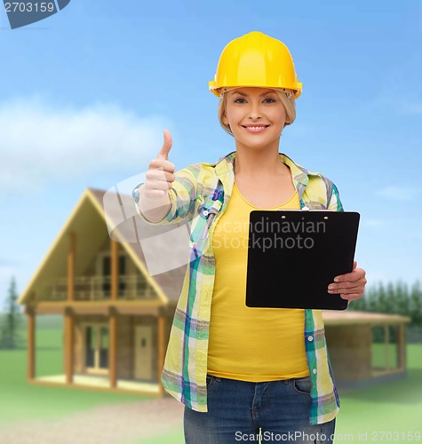 Image of smiling woman in helmet with clipboard