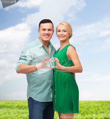 Image of smiling couple showing heart with hands