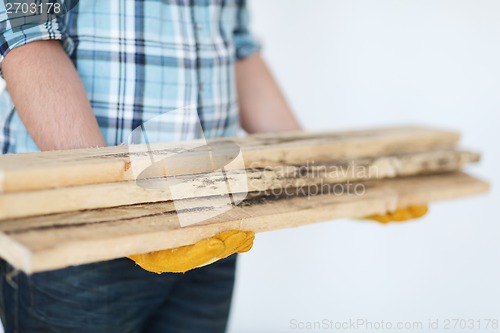 Image of close up of male in gloves carrying wooden boards