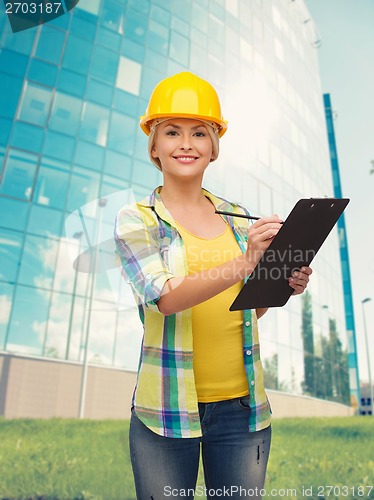 Image of smiling woman in helmet with clipboard