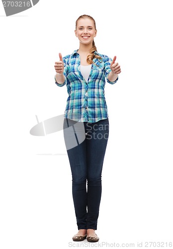 Image of young woman in casual clothes showing thumbs up