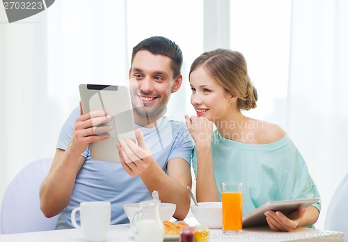 Image of smiling couple with tablet pc reading news