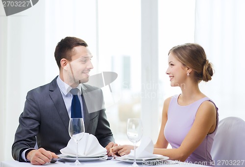 Image of smiling couple looking at each other at restaurant
