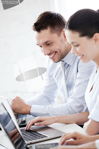 Image of man and woman working with laptop in office