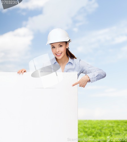 Image of businesswoman in helmet pointing finger to board
