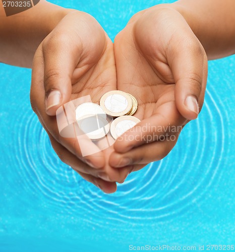 Image of womans cupped hands showing euro coins