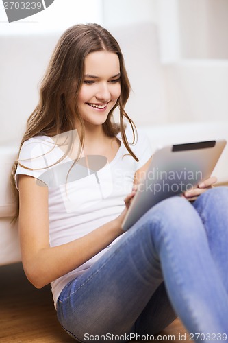 Image of smiling teenage girl with tablet pc at home