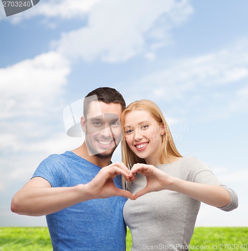 Image of smiling couple showing heart with hands