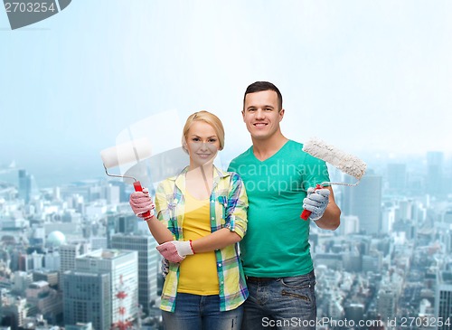 Image of smiling couple in gloves with paint rollers