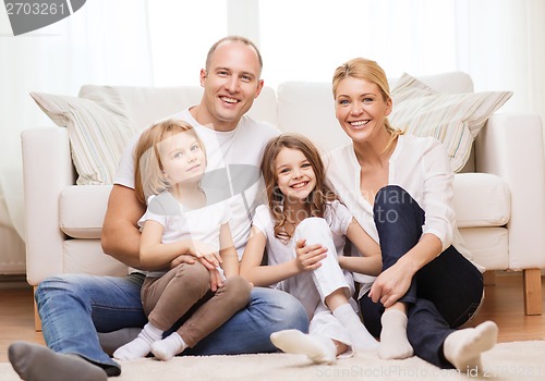 Image of parents and two girls sitting on floor at home