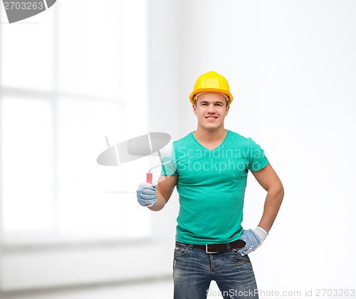 Image of smiling manual worker in helmet with paint roller