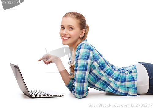 Image of smiling woman with laptop and pointing finger
