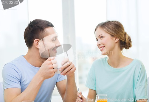 Image of smiling couple having breakfast at home