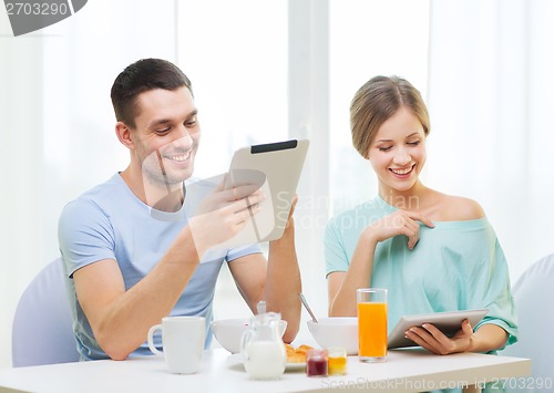 Image of smiling couple with tablet pc reading news