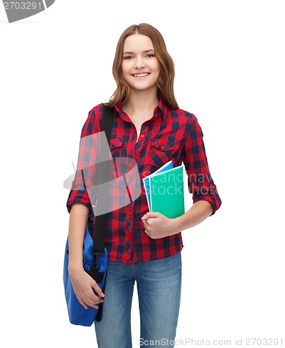 Image of smiling female student with bag and notebooks