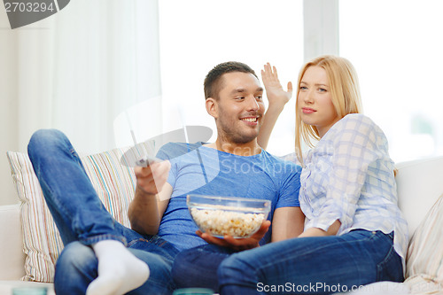 Image of smiling couple with popcorn choosing what to watch