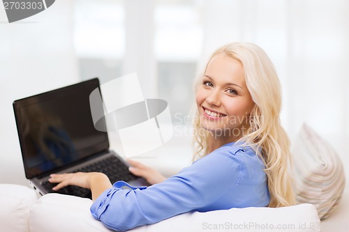 Image of smiling woman with laptop computer at home