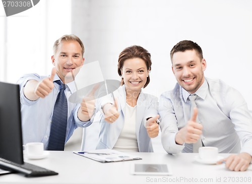 Image of  business team showing thumbs up in office