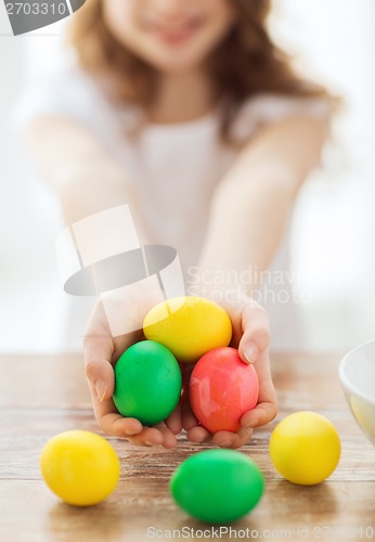 Image of close up of girl holding colored eggs