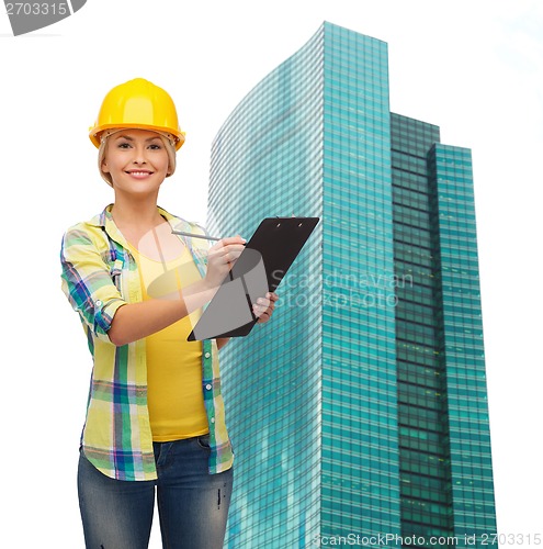 Image of smiling woman in helmet with clipboard