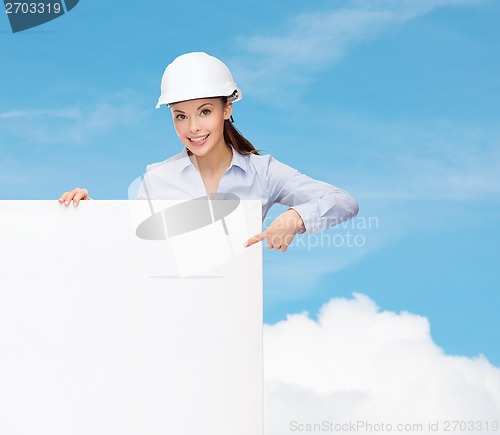 Image of businesswoman in helmet pointing finger to board