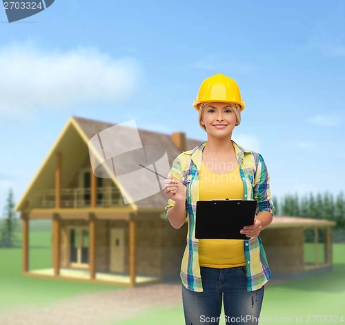 Image of smiling woman in helmet with clipboard