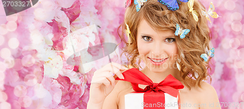 Image of teenager with butterflies in hair opening present