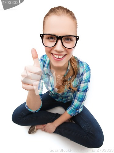 Image of smiling woman in eyeglasses and showing thumbs up