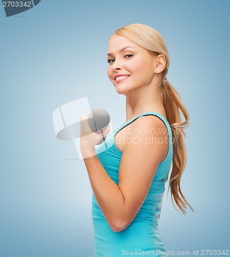 Image of young sporty woman with light dumbbells