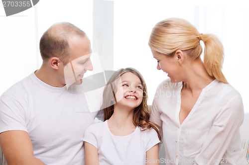 Image of smiling parents and little girl at home