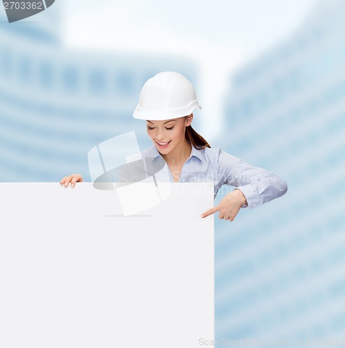 Image of businesswoman in helmet pointing finger to board