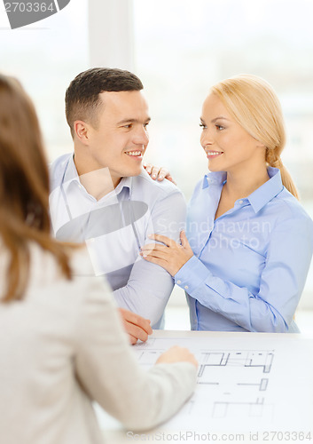 Image of smiling couple looking at blueprint