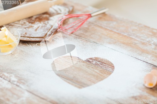 Image of close up of heart of flour on wooden table at home
