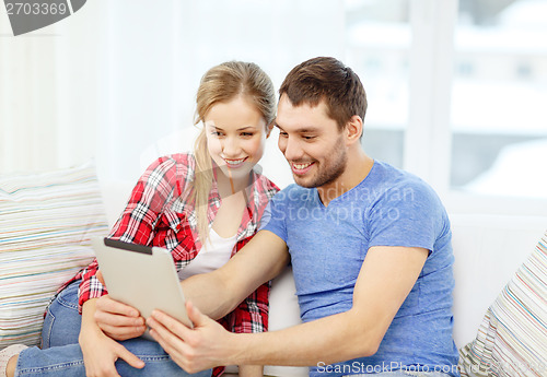 Image of smiling couple with tablet pc computer at home