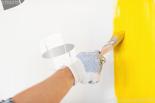 Image of close up of male in gloves holding paintbrush