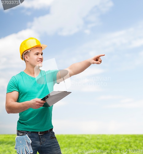 Image of smiling man in helmet with clipboard